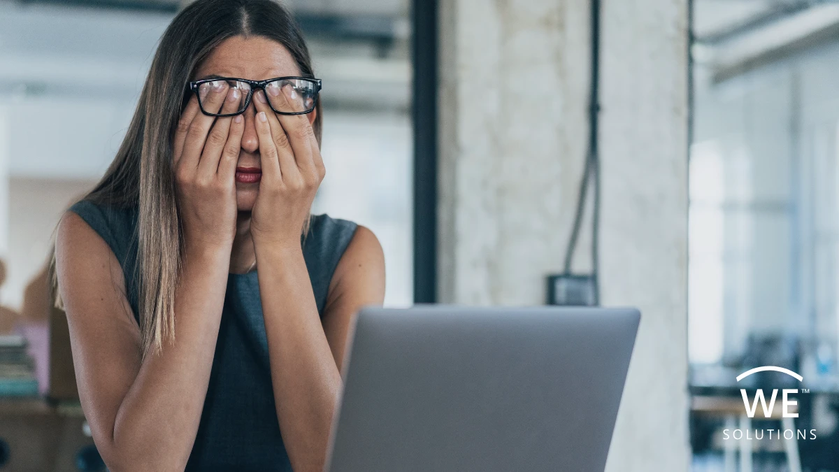 Woman rubbing her eyes while using a laptop during prolonged screen time.